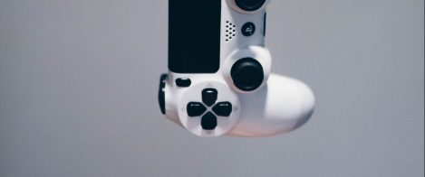 a playstation controller suspended above a gamers hand