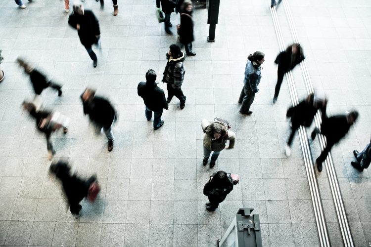 a busy public area with people blurred by the motion of their speed