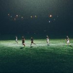 Players play soccer at night under the lights