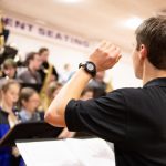 A conducted conducts a high school band.