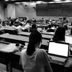 Learners study, perhaps using Moodle, in a socially distanced lecture hall.
