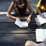 college students work at an outdoor picnic table