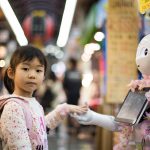 A girl holds hands with a humanoid robot