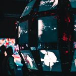 People stand in front of a futuristic digital display.