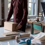 An entrepreneur wraps up a package to be shipped.