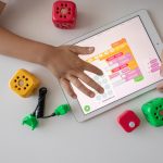 A neurodiverse learner uses a tablet and robotics learning module.