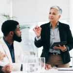 Woman leading a business meeting of three people.